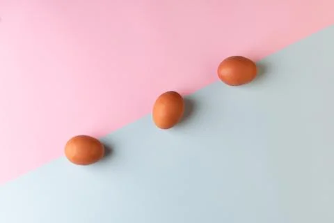 Three easter eggs on a two-color background. Flat lay minimalism. 스톡 사진