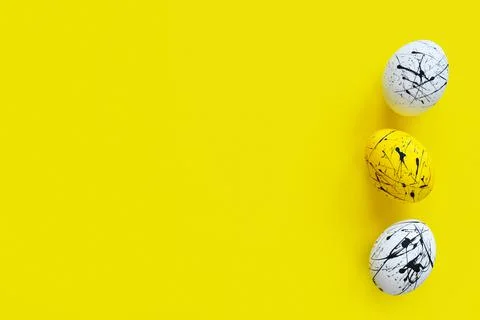 Three Easter eggs on a yellow background. Happy Easter. Minimalism. Backgroun Stock Photos