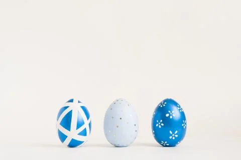 Three Easter golden decorated eggs on blue background. Minimal easter concept 스톡 사진