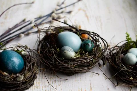 Three easter nest with easter eggs on a wooden background Stock Photos