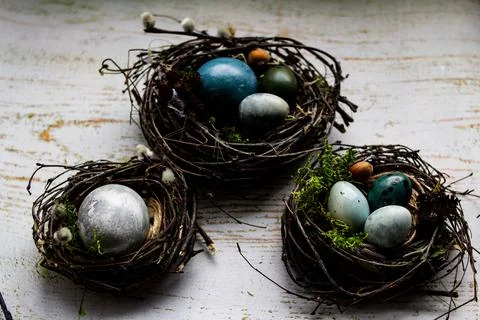 Three Easter nests with Easter eggs on a wooden background Stock Photos
