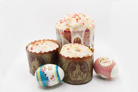 Three Easter Orthodox cakes and colored eggs on a white background Stock Photos