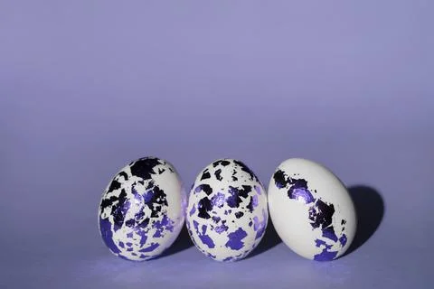 Three Easter white eggs decorated with colored blue-purple foil Stock Photos