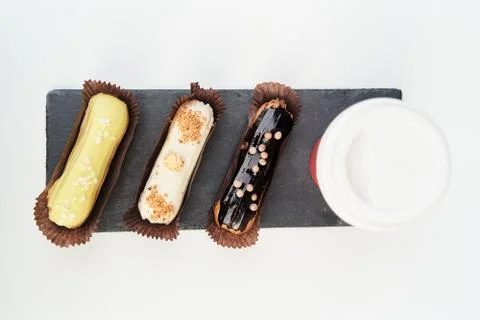 Three eclairs on a black tray top view Stock Photos
