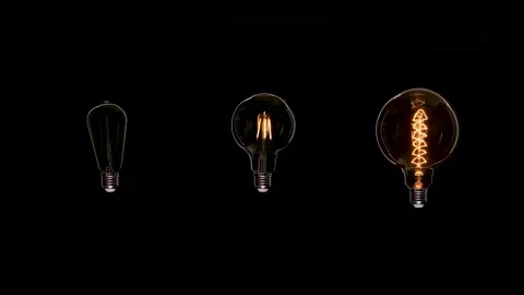 Three Edison dirty bulbs with dust inside glass flicker on black background Stock Footage 135164997