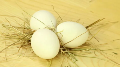 Three eggs are rotated on a background of wooden boards Stock Footage 42916274