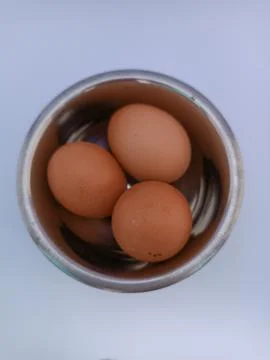 Three eggs in a bowl Stock Photos