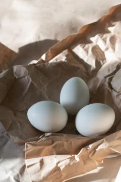 Three eggs on crumpled paper. Stock Photos
