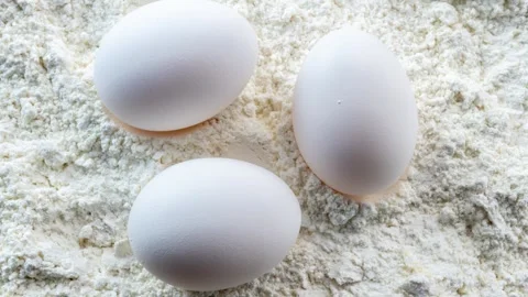 Three Eggs On Flour, Close-Up Shot Stock Footage 337671031