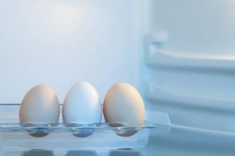 Three eggs in fridge Stock Photos