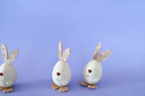 Three eggs with funny faces and bunny ears. Stop motion. Funny cartoon faces. Stock Footage 332162977