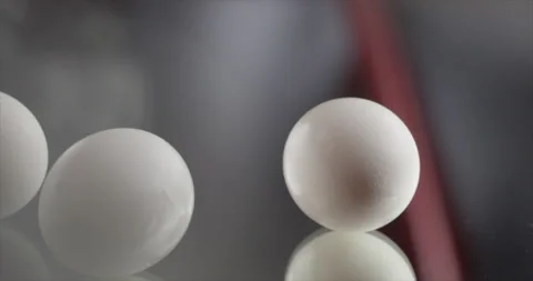 Three eggs roll on a mirrored surface Stock Footage 200255534