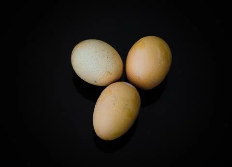 Three eggs with shell on black background Stock-Fotos