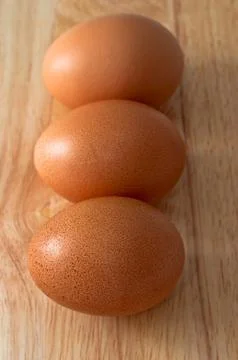 Three eggs on top the chopping board. Foto stock