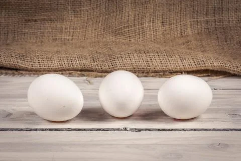 Three eggs on a wooden table Stock Photos