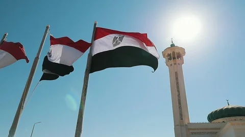 Three Egyptian flags with stripes and a high muslim tower in slo-mo Video stock 101259125