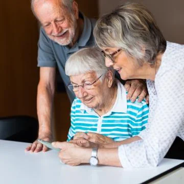 Three elderly persons using smart phone Stock Photos