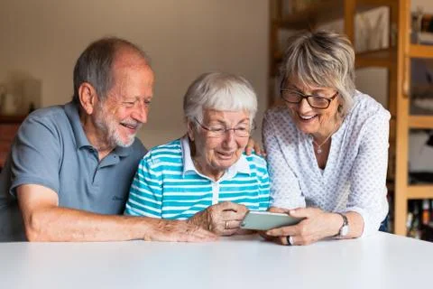 Three elderly persons using smart phone Stock Photos