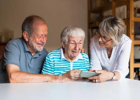 Three elderly persons using smart phone Stock Photos
