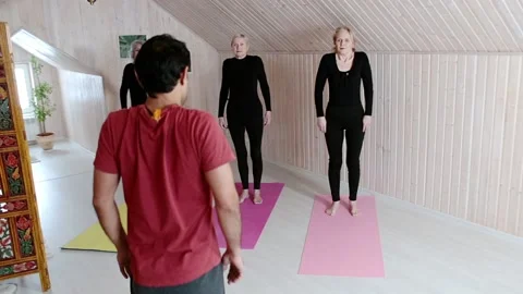 Three elderly women practice yoga exercises with an instructor at home. Stock Footage 151720439