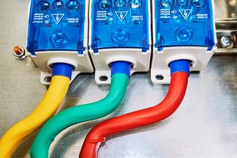 Three electrical cables or wires are connected to the distribution units. Stock Photos