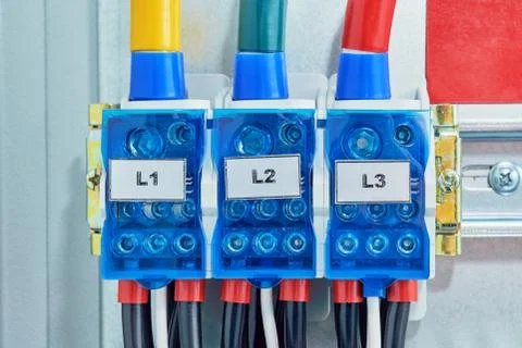 Three electrical cables or wires are connected to the distribution units. Stock Photos