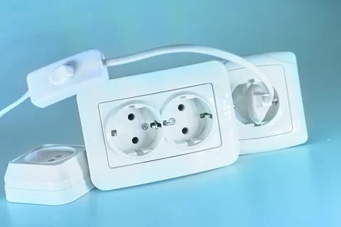 Three electrical sockets for connecting devices and a switch on blue Stock Photos