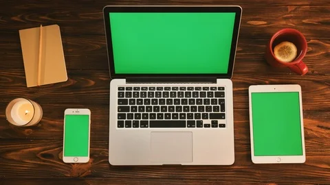 Three electronic devices with green screen on the wooden table. Laptop computer Stock Footage 80898758