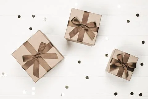 Three elegant gift boxes with brown ribbon on a white background Stock Photos