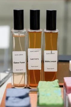 Three elegant room spray bottles displayed on a wooden surface with soap bars Stock Photos