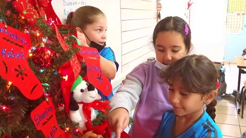 Three Elementary School Girls Inside Classroom Decorating Christmas Tree Stock Footage 221923461