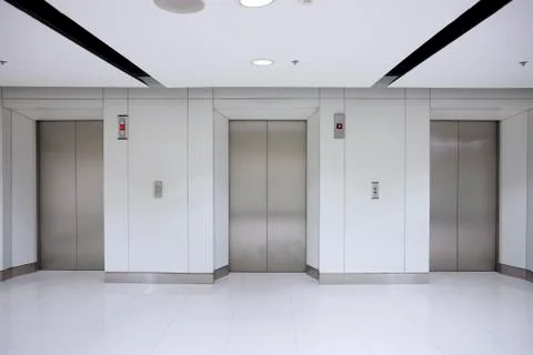 Three elevator doors in corridor of office building Stock Photos