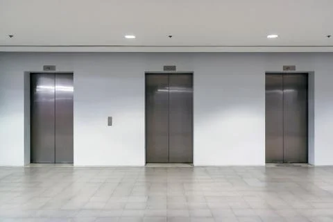 Three elevator doors interior building with low light Foto stock