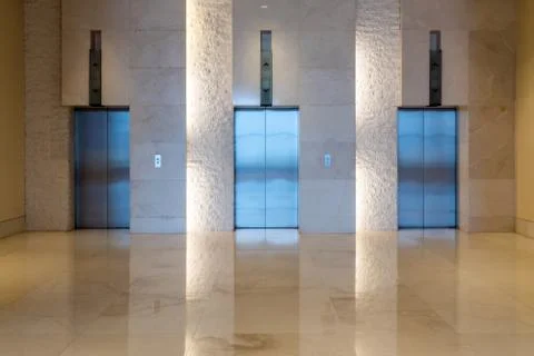 Three elevator doors interior building with low light Stock Photos