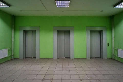 Three elevator doors in a residential building. Wide-angle view of modern ele Stock Photos