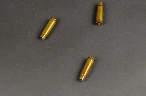 Three empty automatic rifle cartridges on a black background. Close-up. Selec Stock Photos