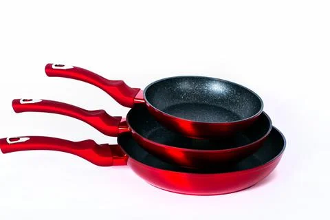 Three empty black-red frying pans on white background. Cooking At Home together  Stock Photos
