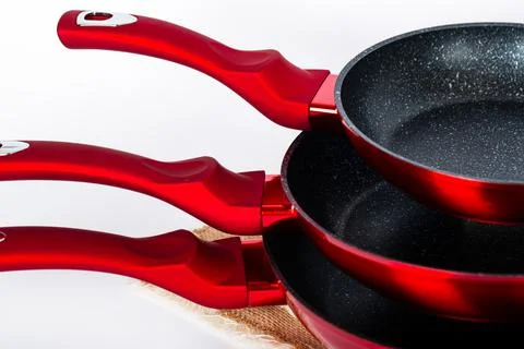 Three empty black-red frying pans on white background. Cooking At Home together  Foto stock