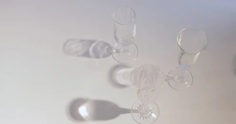 Three empty champagne glasses projecting shadow Stock Footage 142798124