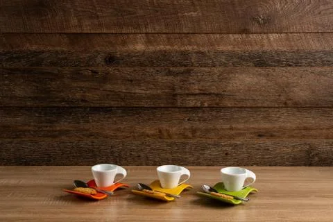 Three empty coffee cups with biscuit and teaspoon nearby Foto stock