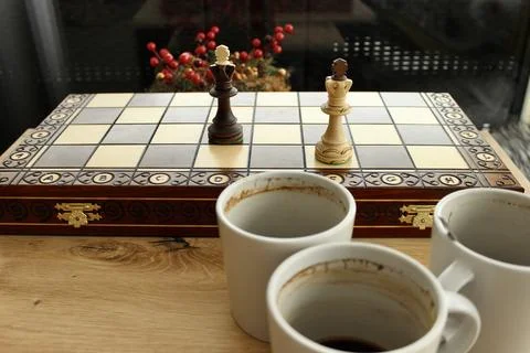 Three empty coffee cups on a checkerboard background Stock Photos