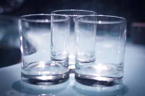 Three empty crystal glasses on dark background Foto stock
