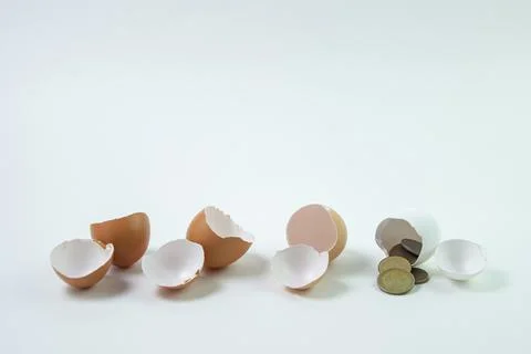 Three empty eggs and one egg with money. Profitable investment. Growth strategy. Stock Photos