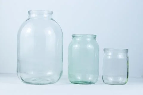 Three empty glass jars of different sizes on a white background Stock Photos