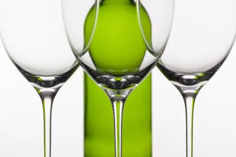 Three empty glasses of wine and green bottle 库存照片