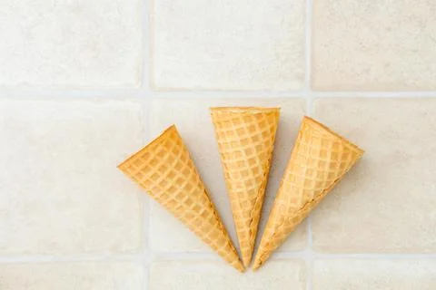 Three empty ice cream waffle cones on a white background, top view Stock Photos