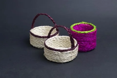 Three empty jute bucket on black background. Stock Photos