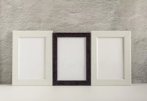 Three empty photo frames in a dark and light frame on a table or shelf with a Foto stock