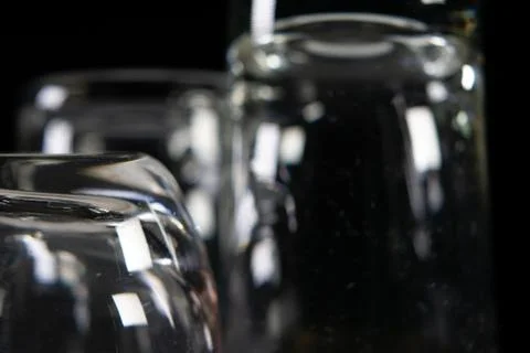 Three empty shot glasses on black background. Stock Photos