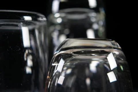Three empty shot glasses on black background. Stock Photos